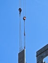 Crane lowering large concrete slab onto building under construction.