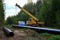 Crane lowers a section of pipe into a trench. Construction of gas pipeline to new LNG plant. Operation install natural gas