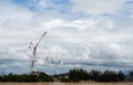 Crane machine with blue sky and clouds background at construction site. Royalty Free Stock Photo