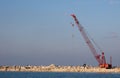 Crane machine building a water barier at a marina