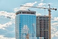 Crane near skyscraper with glass facade at construction site Royalty Free Stock Photo