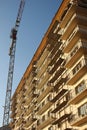 Crane next to building covered in scaffolds Royalty Free Stock Photo