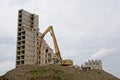 Crane next to a half demolished stripped down apartment tower