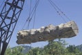 A crane raising a weathered log Royalty Free Stock Photo