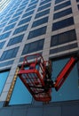 Crane for repair and facing works on the background of a multi-storey office building..