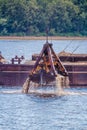 Crane on the ship produces sand on the river Royalty Free Stock Photo