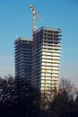 Crane on skyscraper construction site with windows reflecting sky Royalty Free Stock Photo