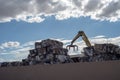 Crane stacking cubes of compressed metal at recycling center