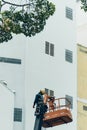 Crane truck on road for group of people working in Saigon,Vietnam, Vietnamese worker work on boom lift to cut branch of tree for