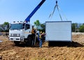 The Crane trucks transport the mobile office buildings or container site office for installation in the construction site area Royalty Free Stock Photo