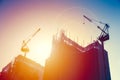 Crane with under construction building with sunset sky. Royalty Free Stock Photo