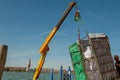 Crane unloading metal baskets with hotel linen in Venice