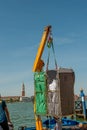 Crane unloading metal baskets with hotel linen in Venice
