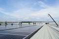 Crane Uploading Solar Panels on Roof with Installation Workers