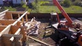 Crane and workers at construction of wooden house. Clip. Top view of working process with team of workers to build