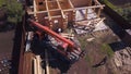 Crane and workers at construction of wooden house. Clip. Top view of working process with team of workers to build