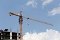 Crane working on a building under construction in day time. Royalty Free Stock Photo