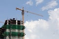 Crane working on a building under construction in day time. Royalty Free Stock Photo