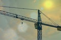 Crane working in construction area with sun flare Royalty Free Stock Photo