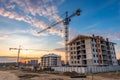 Crane working on construction site at sunset Royalty Free Stock Photo