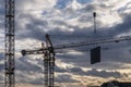 3 cranes against cloudy sunset sky at construction site Royalty Free Stock Photo