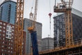 Cranes and building device on a construction site of a skyscraper in dowtown Montreal, surrounded by other high rise towers