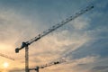 3 cranes at construction site against sunset sky Royalty Free Stock Photo
