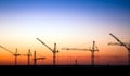 Cranes on a construction site against a sunset sky Royalty Free Stock Photo