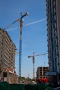 Cranes at the construction site of multi-unit high buildings. Construction of a molded concrete house. New buildings with a large