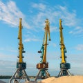 Cranes near the sand against a blue sky. Industrial landscape, industrial zone Royalty Free Stock Photo