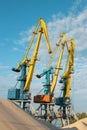 Cranes near the sand against a blue sky. Industrial landscape, industrial zone Royalty Free Stock Photo