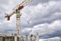 Cranes over the construction site with cloudy sky background Royalty Free Stock Photo