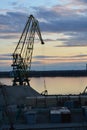 Cranes over the river in the port at sunset Royalty Free Stock Photo