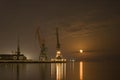 Cranes in the port and reflection of moon