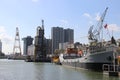 Cranes, ships and lighthouse at the maritime museum in Rotterdam on the public street in the Netherlands.