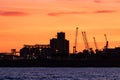 Cranes, silos and warehouses at an industrial harbor, evening time, sunset at the port. Tarragona by the Mediterranean sea, Royalty Free Stock Photo