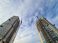 Cranes standing near multi-storey buildings under construction against background of blue sky bottom view Royalty Free Stock Photo