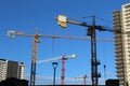 Cranes and under-construction apartment building against blue sky - Construction of modern building Royalty Free Stock Photo