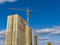 Cranes work at a construction site. New brick houses Royalty Free Stock Photo