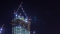 Cranes working on big constraction site works of new skyscraper night timelapse