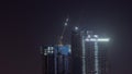 Cranes working on constraction site works of new skyscrapers night timelapse