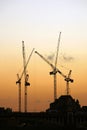 Cranes working over sunset