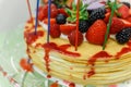 Crape Cake on top with Mixed Berries and Strawberry Sauce