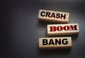 Crash boom bang words on wooden blocks on black background. Unexpected crisis, failure or bankruptcy business concept. End of