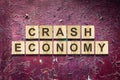 Crash. Economy. The inscription on wooden blocks against the background of a red cracked wall. The fall of the economy Royalty Free Stock Photo