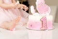 Crash pink cake at the celebration of the first birthday of the girl, ruined sponge cake, broken marshmallow, 1 year Royalty Free Stock Photo