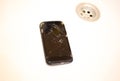 Crashed black smartphone in lying in the white wash basin sink. Broken lcd touch screen in the bathroom. Information technology Royalty Free Stock Photo