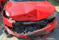 Crashed car of red color. Front view of the wrecked vehicle. The car crash. Abandoned passenger car is completely broken