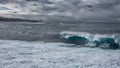 A breaking wave crashing on a long coastal edge.