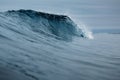 Crashing glassy wave on sandy beach. Perfect swell for surfing